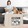 A woman is sitting on a couch, reading a book, while a dog is sitting next to her. In the foreground, there is a large canvas bag with a custom design featuring a collage of four dog portraits.
