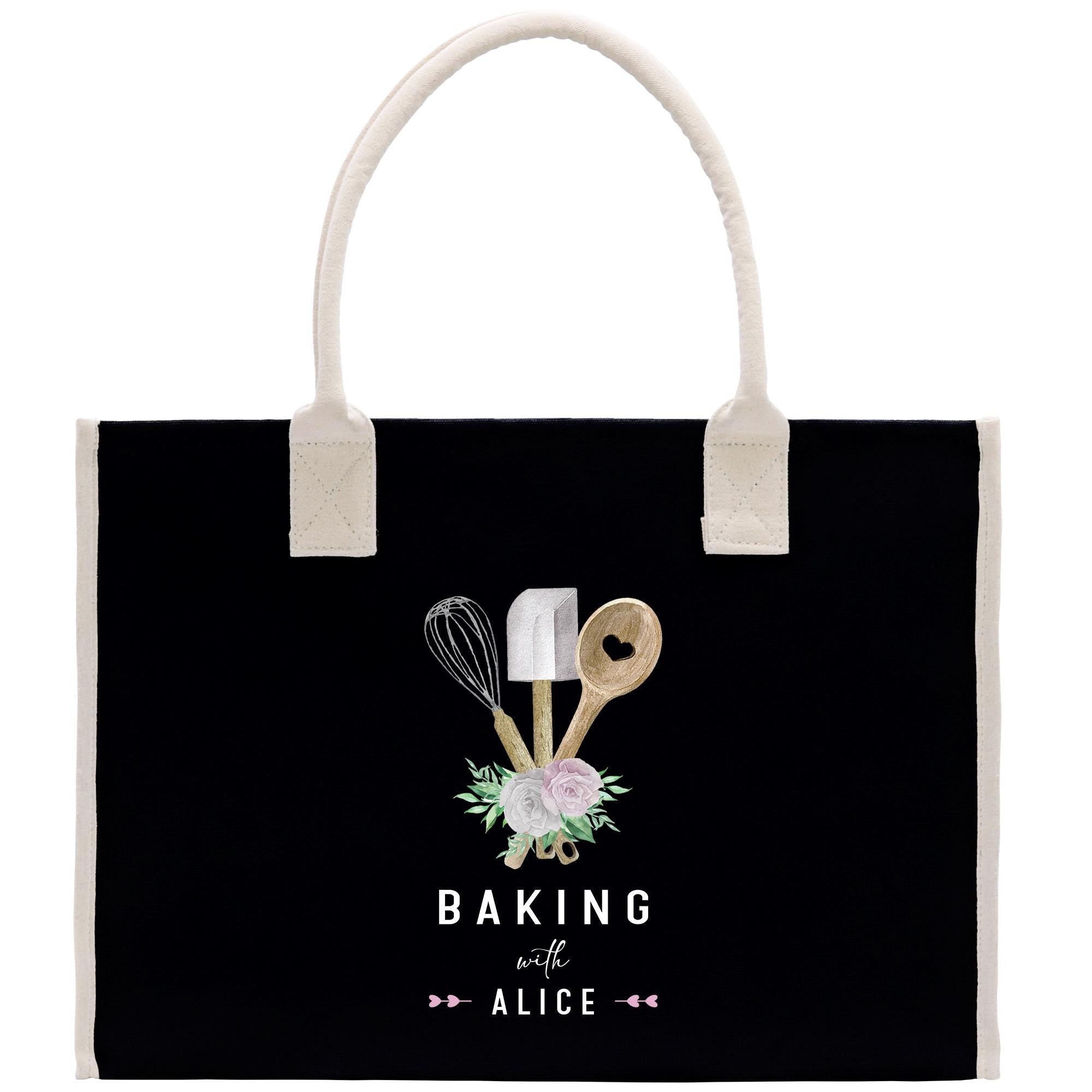 A black tote bag with a white handle and a design featuring baking utensils and flowers.