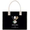 A black tote bag with a white handle and a design featuring baking utensils and flowers.