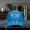 A blue baseball cap with the text "N° 50 EMILY JOHNSON AUSTIN, TEXAS" printed on it, placed on a marble countertop.