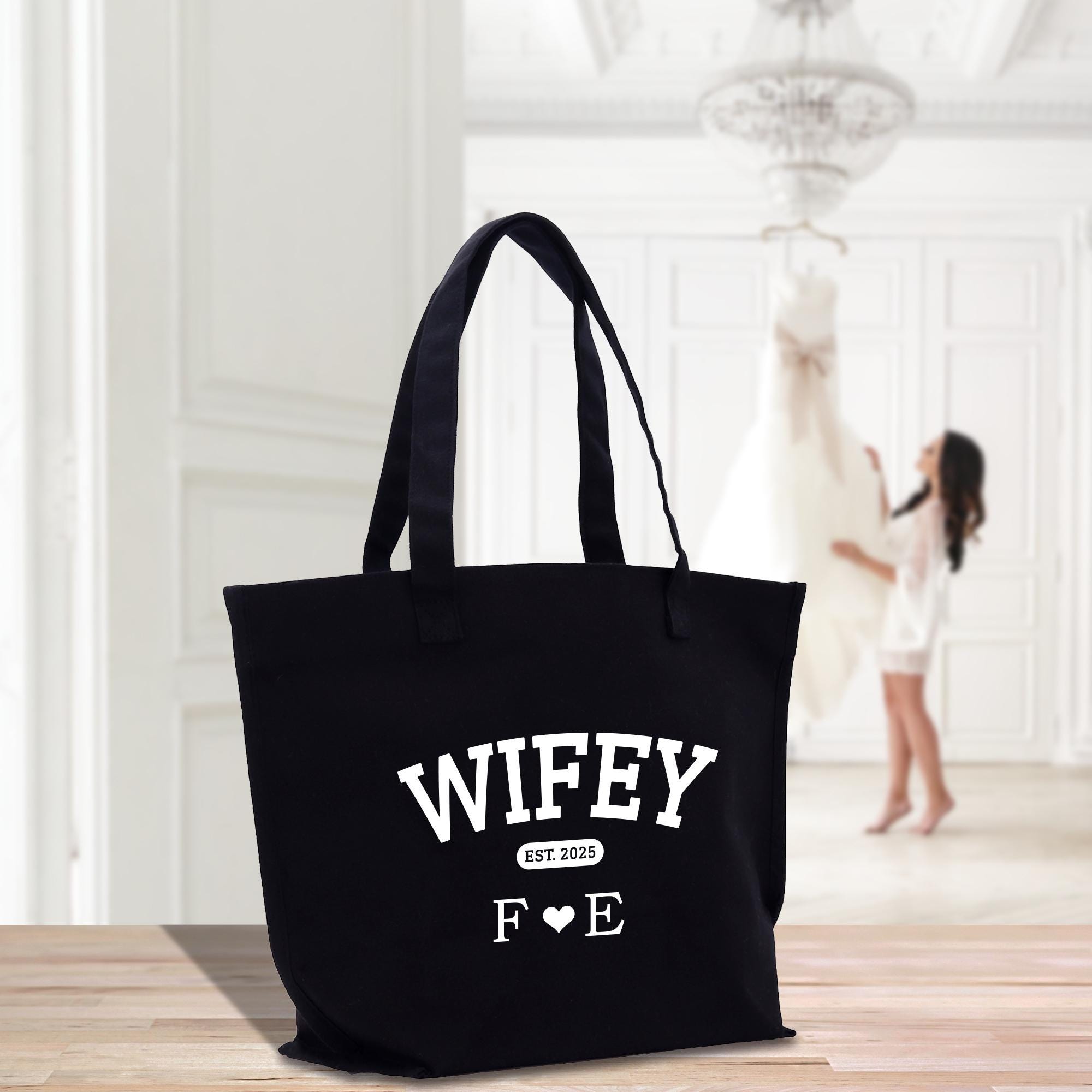 a black tote bag sitting on top of a wooden table