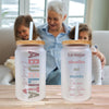 a woman and a child sitting at a table with two water bottles