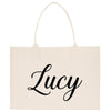 A beige canvas tote bag with the name "Lucy" printed in a cursive font.