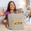 a woman sitting on a couch holding a bag with sunflowers on it