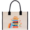 A tote bag with a stack of colorful books and a cat on top, surrounded by flowers.