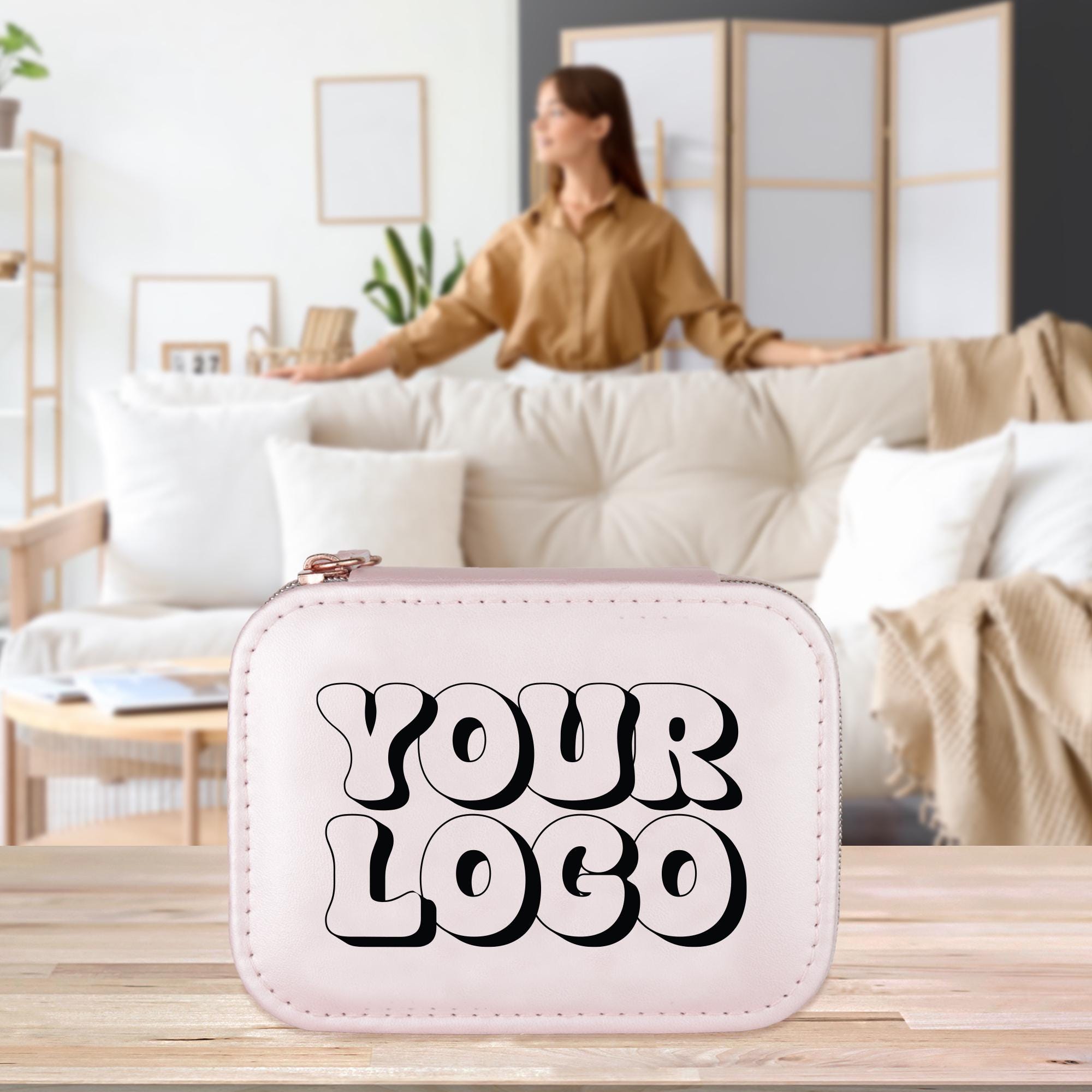 A woman is standing in a living room, with a white leather case featuring the text &quot;YOUR LOGO&quot; in the foreground.