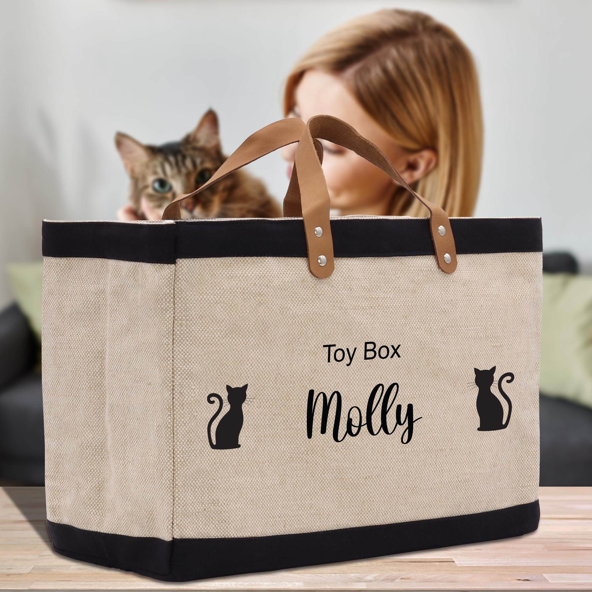 a woman is holding a canvas bag with a cat in it