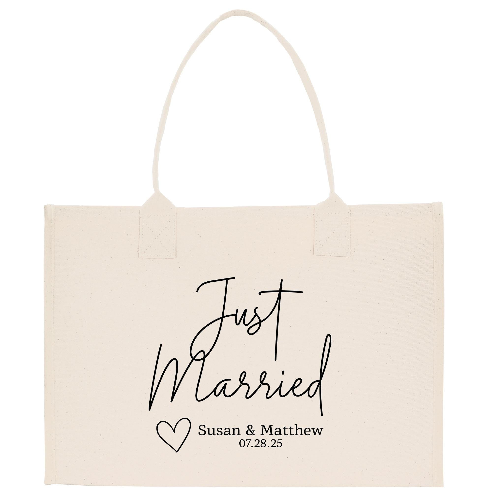 A beige canvas tote bag with the text &quot;Just Married Susan & Matthew 07.28.25&quot; printed on it.