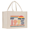A beige canvas tote bag with a graphic design featuring a sunset, mountains, and the text 