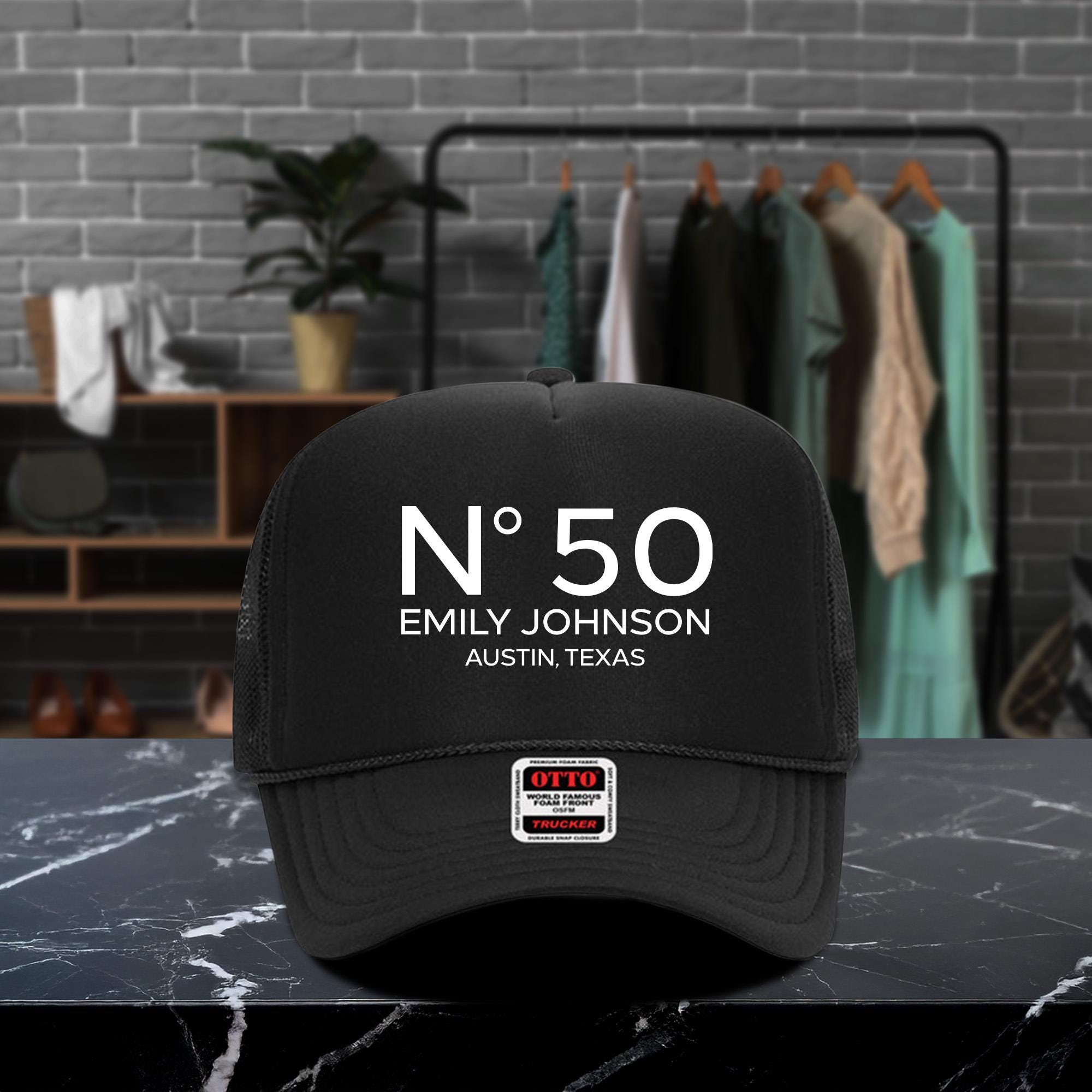A black baseball cap with white text and a small patch on the front, placed on a marble countertop.