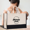 a woman holding a bag with a baby inside of it