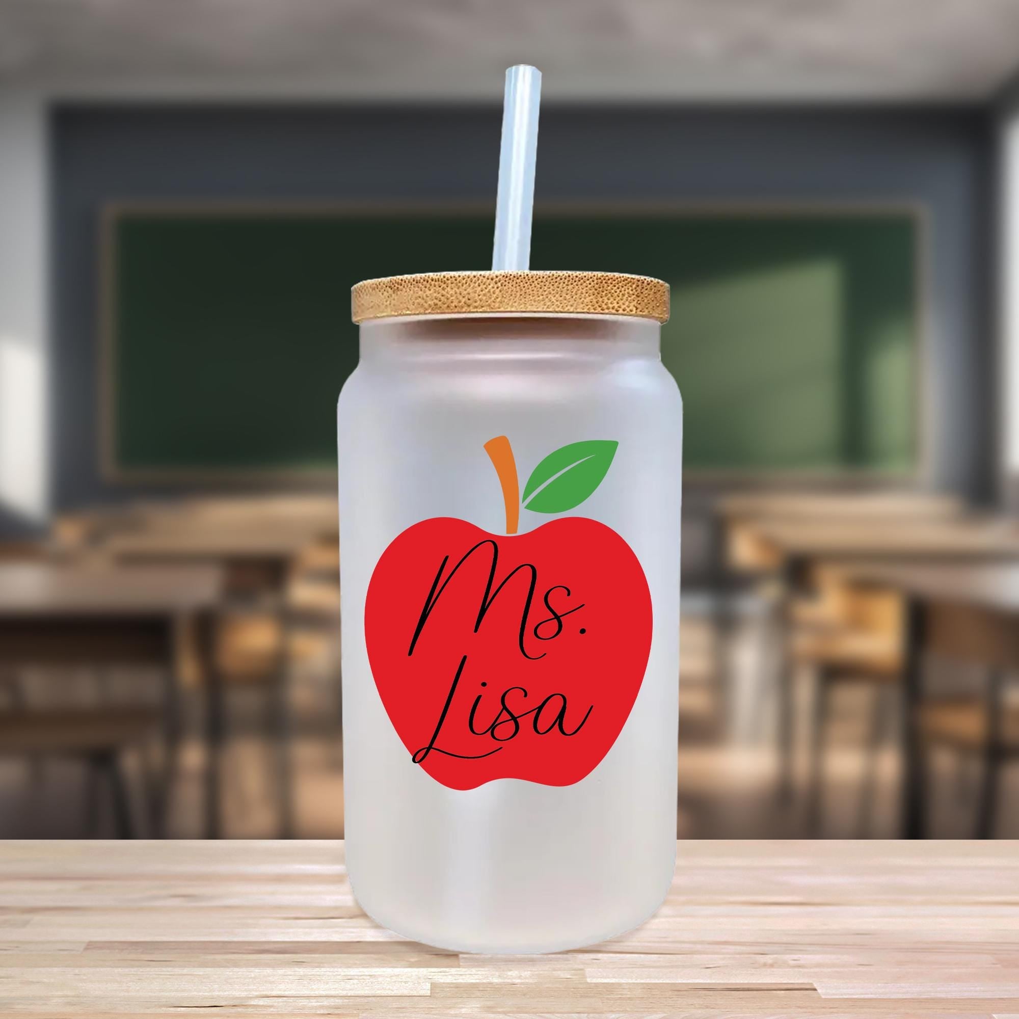 a glass jar with a straw and a red apple on it