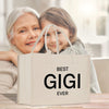 an older woman and a young girl holding a bag that says best gig ever