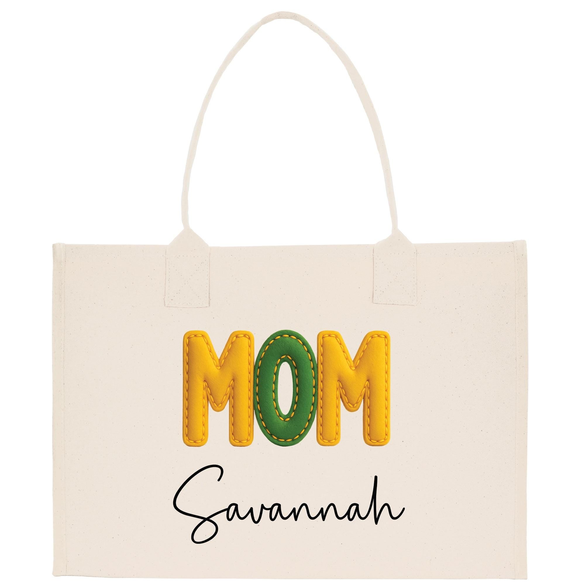 A white tote bag with the word &quot;MOM&quot; printed in large yellow letters and the name &quot;Savannah&quot; written below in smaller black letters.