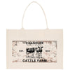 a beige canvas tote bag with a printed design on it. The design includes a vintage-style illustration of two cows, along with text that reads "CHANDLER, DETROIT, MICHIGAN, EST. 1950, CATTLE FARM".