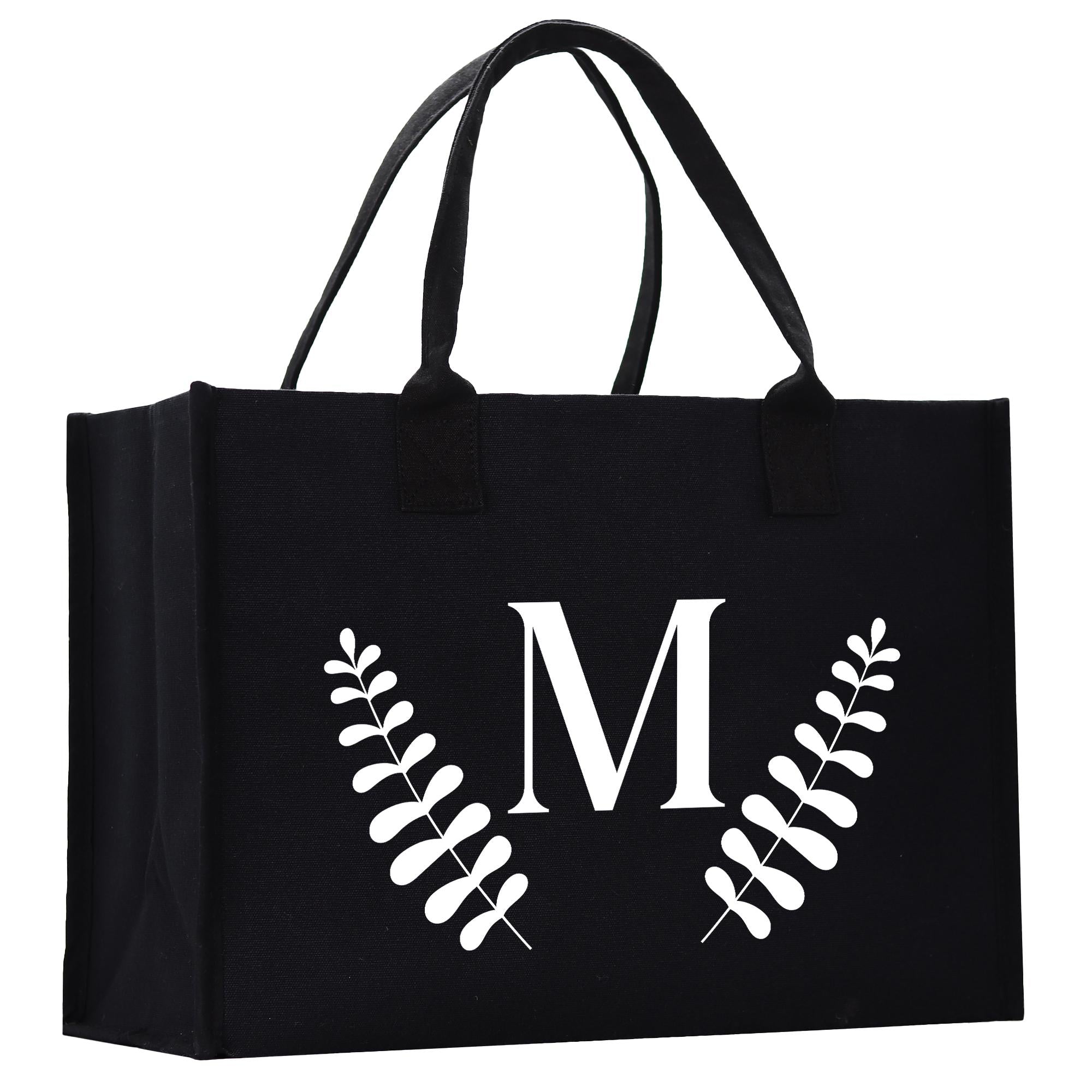 A black tote bag with a white monogrammed letter &quot;M&quot; on it.
