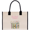 A beige tote bag with a floral design and a row of colorful books titled "MIDNIGHT'S REVIEW" printed on it.