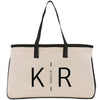A beige tote bag with black straps and handles, featuring the text "KIR" printed on it.