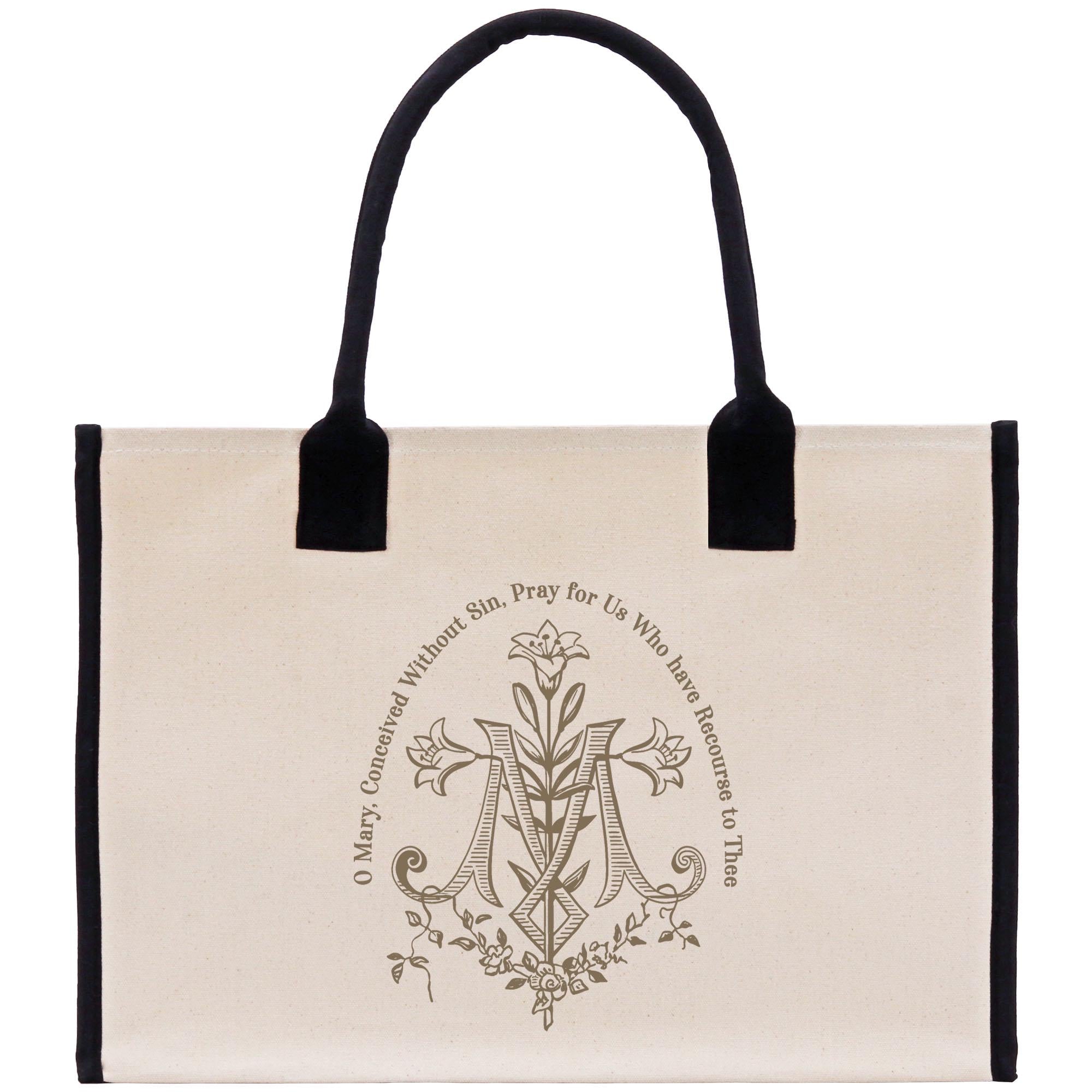 A beige canvas tote bag with a black handle and trim, featuring an ornate monogram design and text.