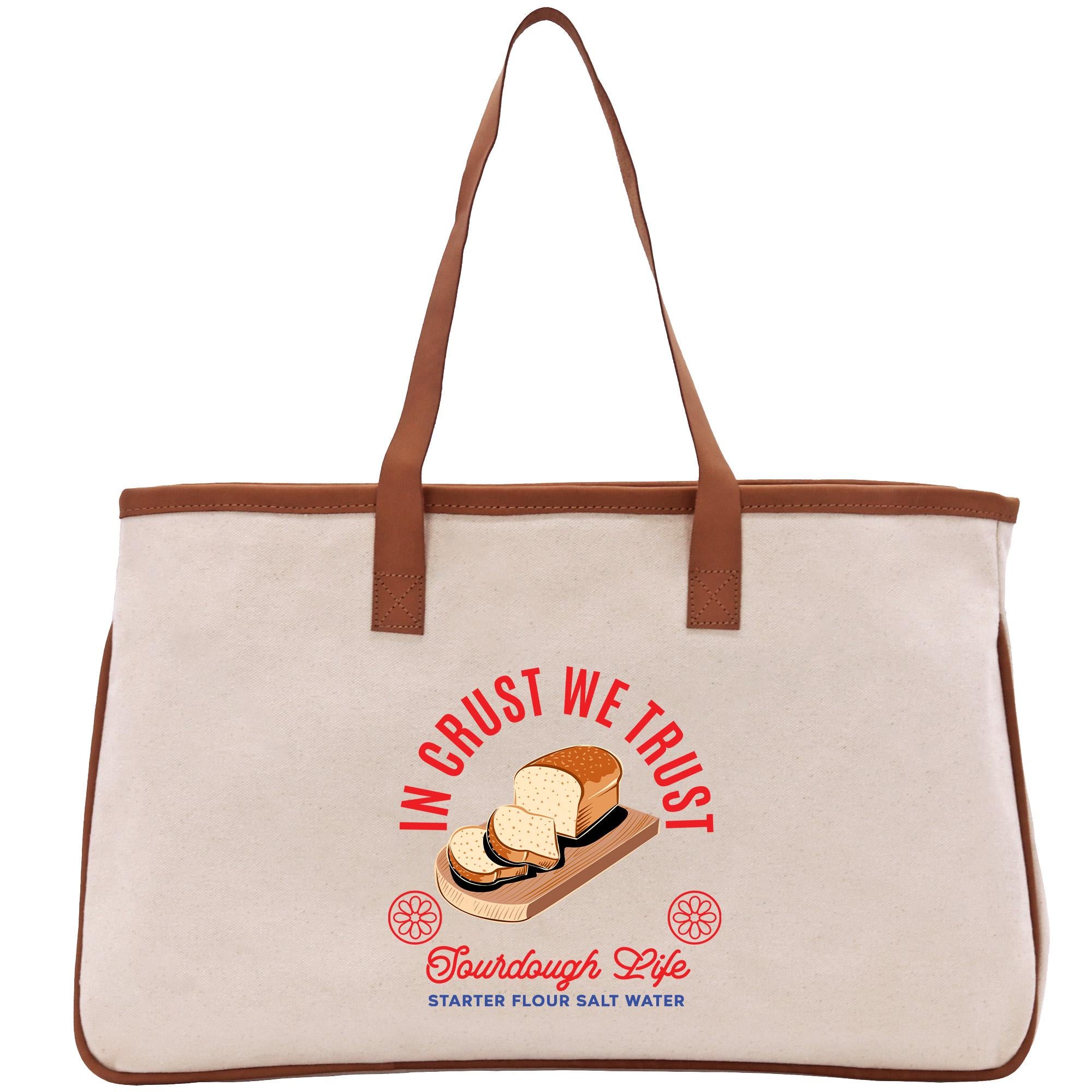 A beige tote bag with a graphic design featuring a loaf of bread and the text &quot;In trust we trust&quot; printed on it.