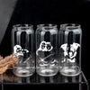 Three clear glass tumblers with black and white illustrations of people and dogs printed on them.