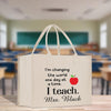 a white bag that says i'm changing the world at a time i teach