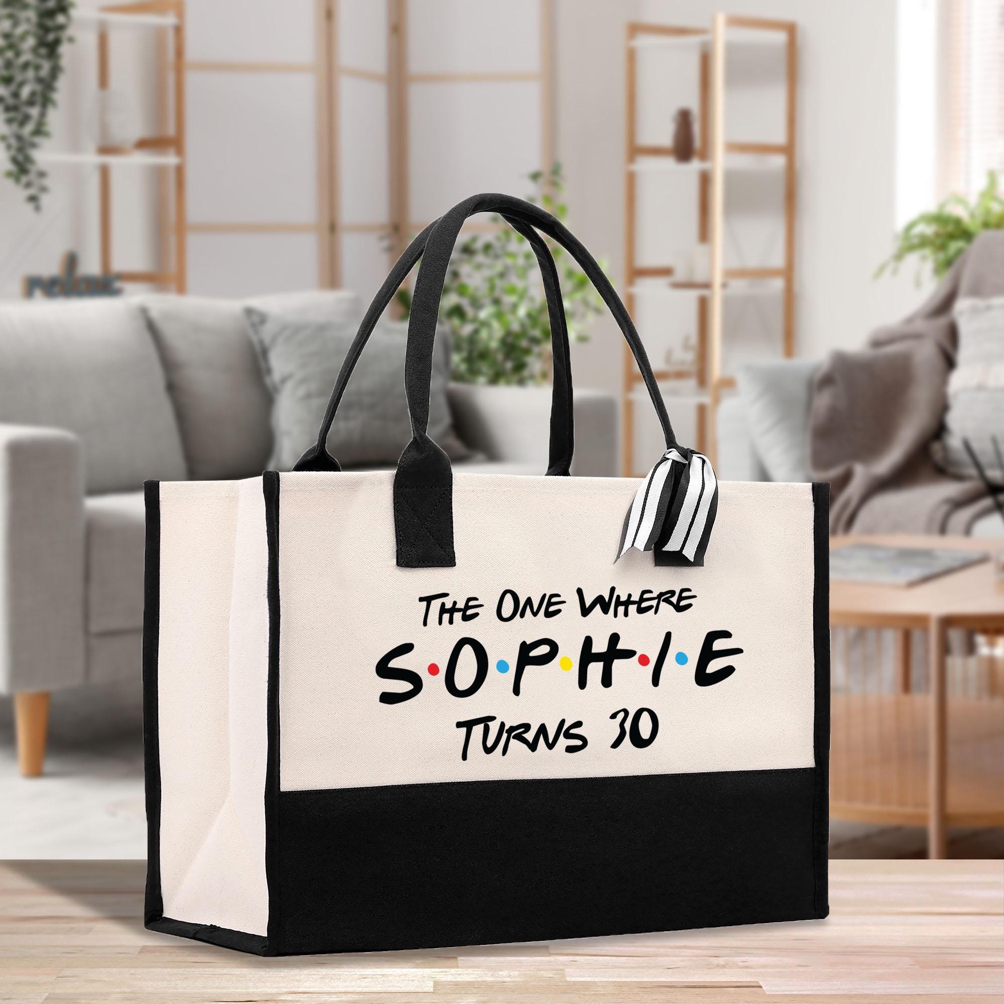 a black and white bag sitting on top of a wooden table