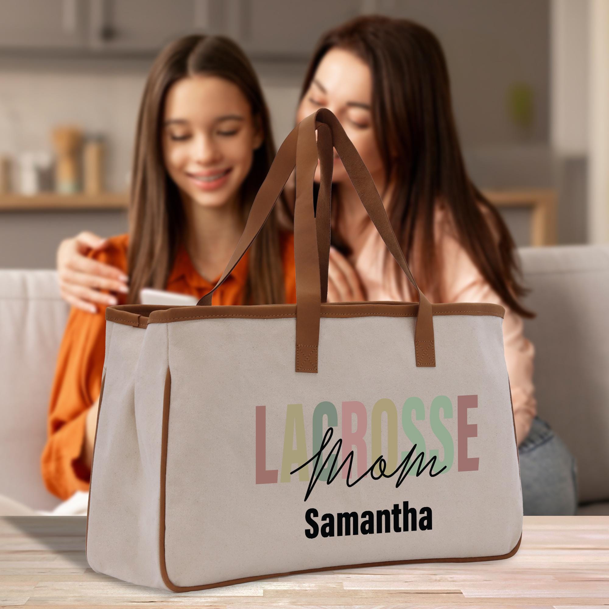 two girls sitting on a couch looking at a bag