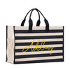A black and white striped tote bag with the name "Ashley" printed in yellow on the front.