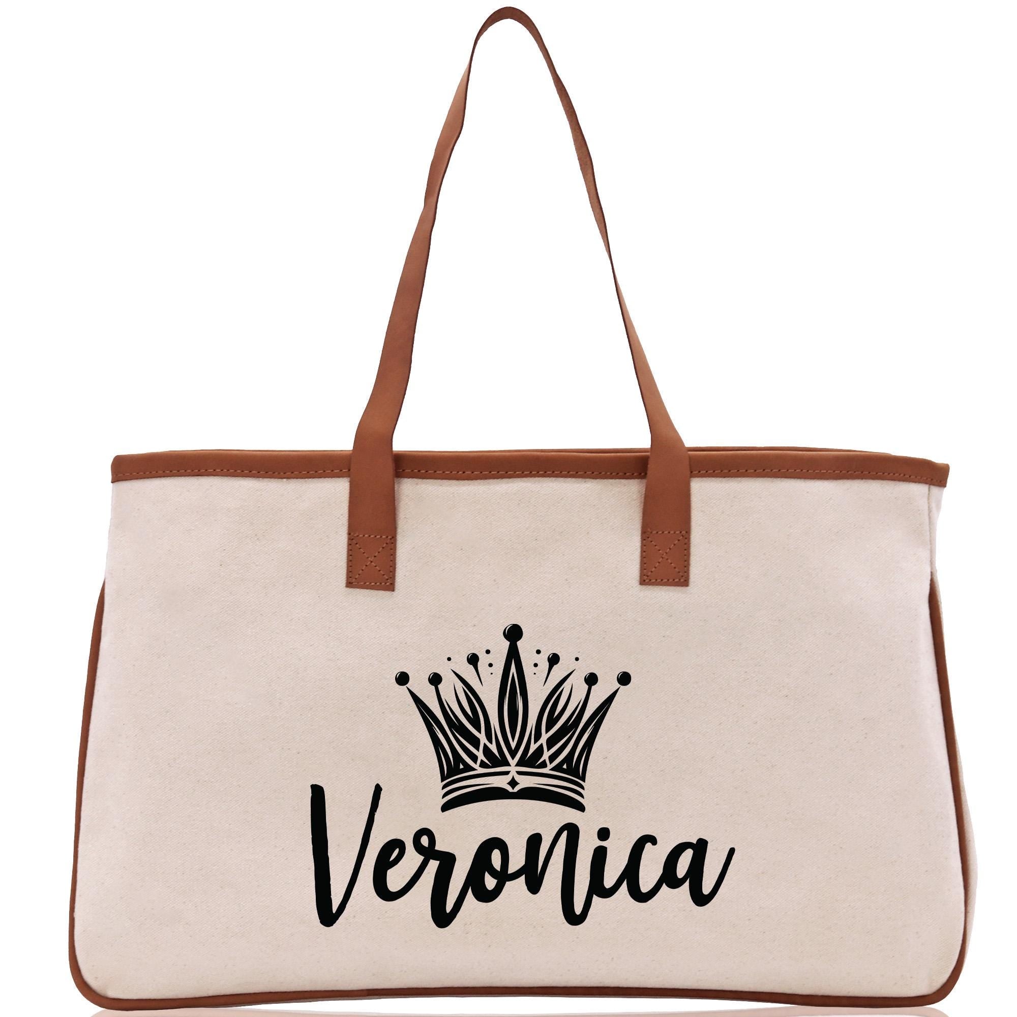 A beige canvas tote bag with a brown leather strap and a black crown logo printed on it.
