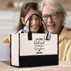 an older woman and a young girl holding a black and white shopping bag