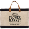 A beige tote bag with a black handle and strap, featuring a printed design that says "FRESH FLOWER MARKET" and lists various types of flowers such as tulips, roses, peonies, and daisies.