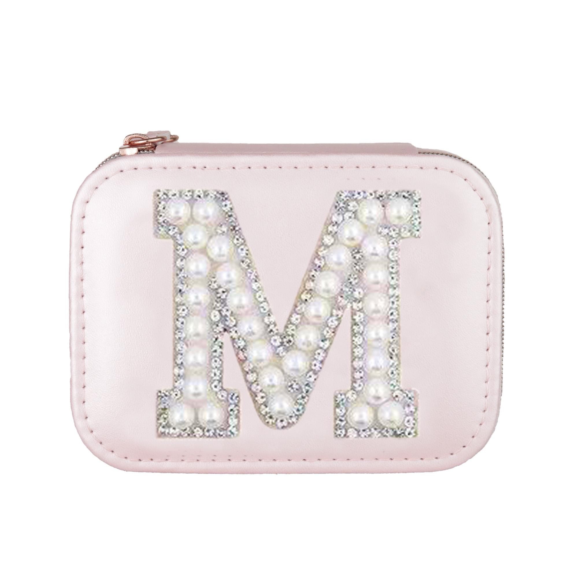 A pink leather pouch or case with a large letter &quot;M&quot; decorated with rhinestones and pearls.