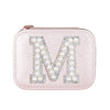 A pink leather pouch or case with a large letter "M" decorated with rhinestones and pearls.