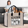 A woman is sitting on a couch, reading a book, while a dog is in the background. A large tote bag with a custom dog image printed on it is placed in front of the woman.