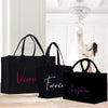 three black shopping bags sitting on top of a wooden table