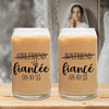 Two glass tumblers with text that reads "GIRLFRIEND fiancee 08-10-25" and "BOYFRIEND fiancee 08-10-25" printed on them, placed on a wooden surface.