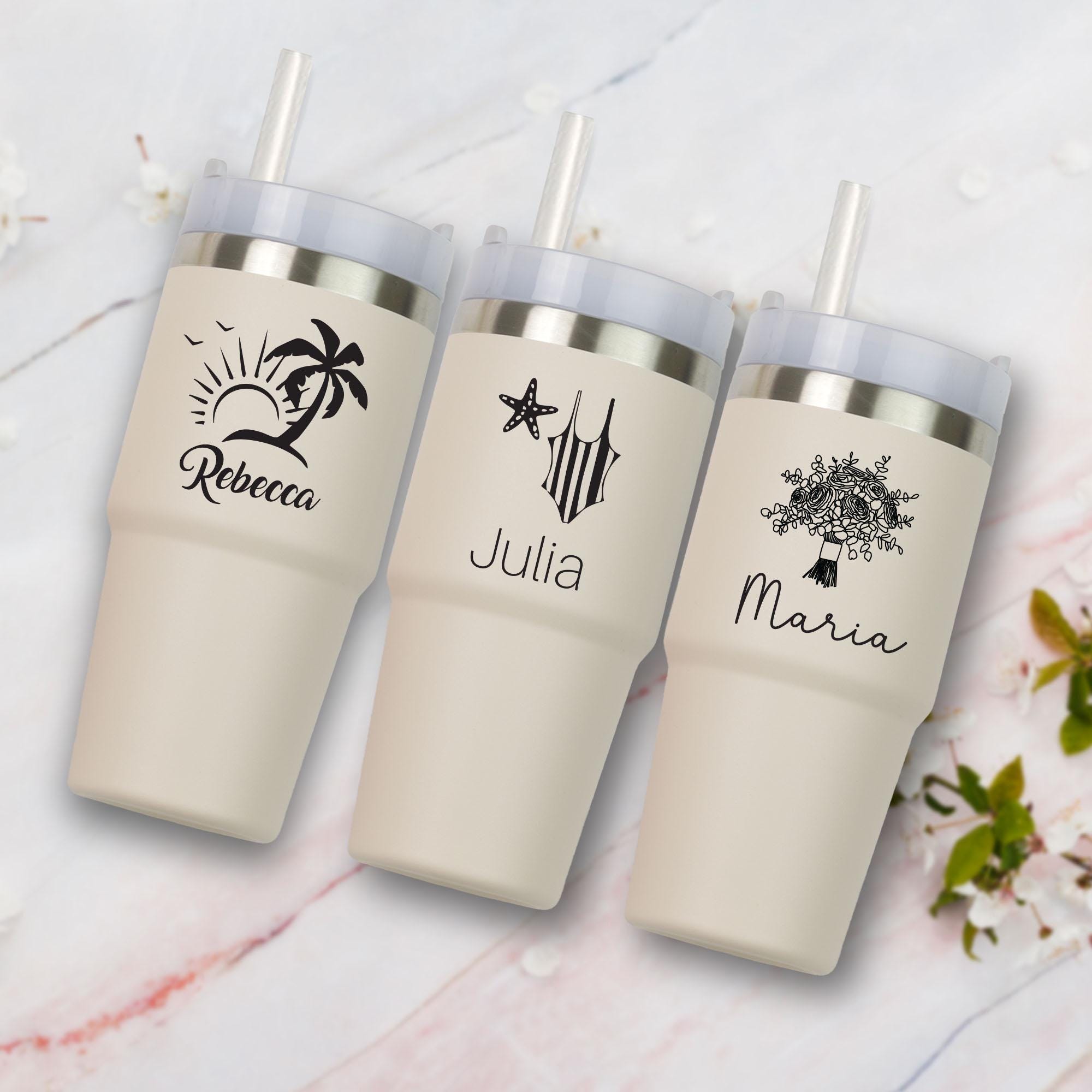 three travel mugs sitting on a marble surface