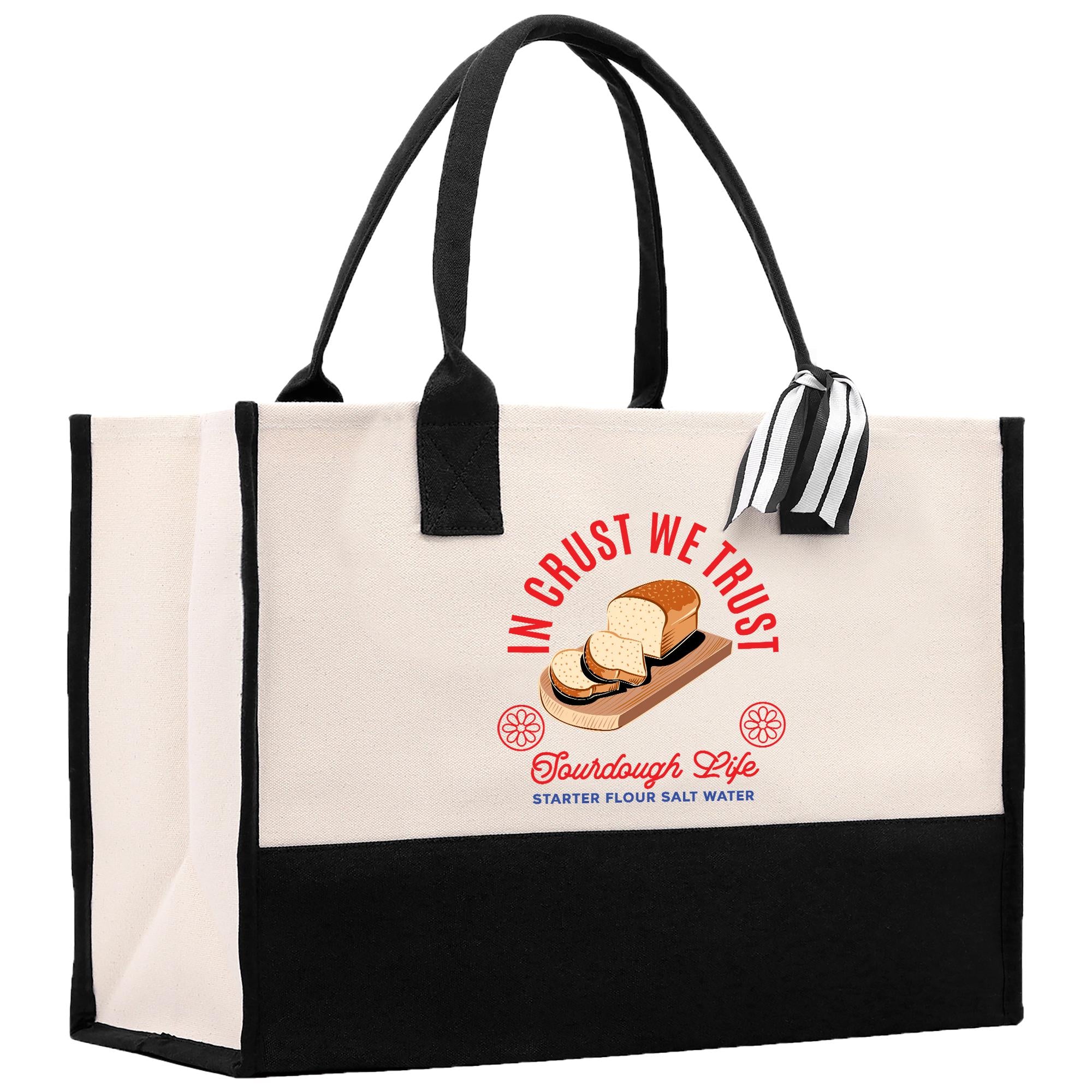 A tote bag with a printed design on it, featuring a loaf of bread and the text &quot;InCRUST WE TRUST&quot; along with the text &quot;Tou Dough Life&quot; and &quot; starter flour salt water&quot;.
