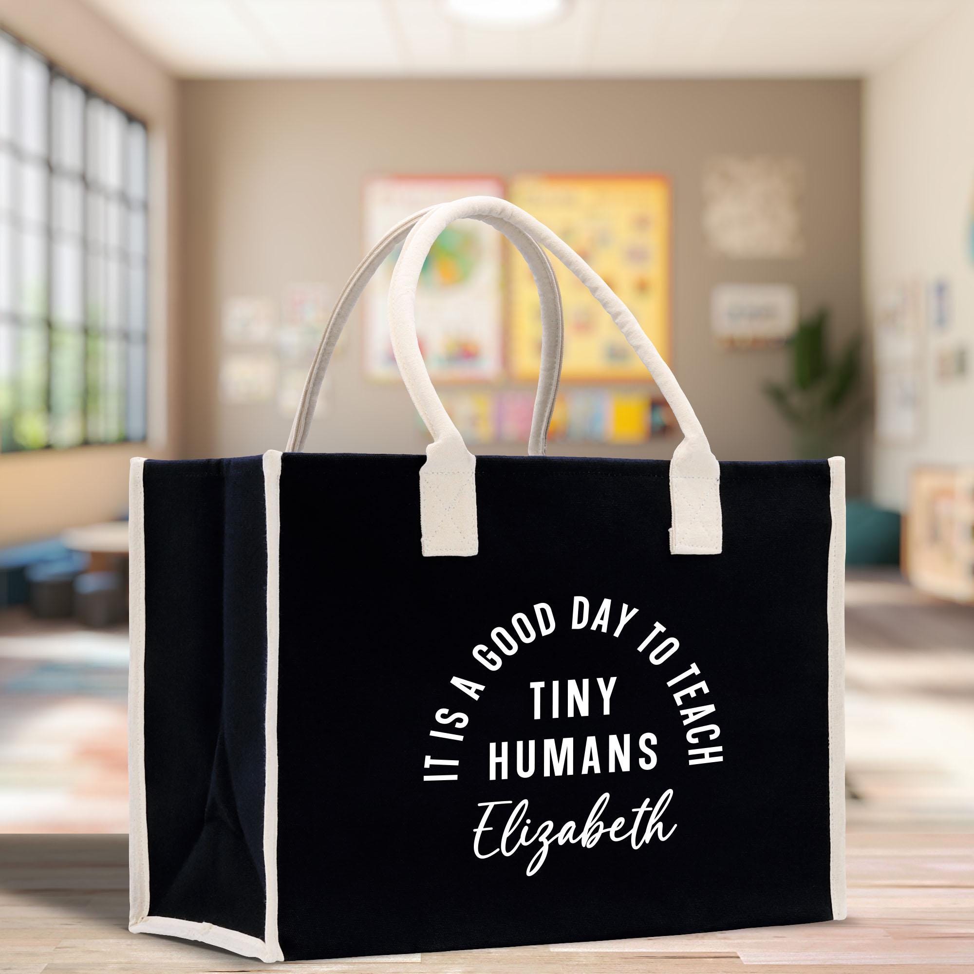 a black shopping bag with white handles on a table