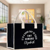 a black shopping bag with white handles on a table