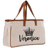 A beige tote bag with a brown handle and a black crown design printed on it.