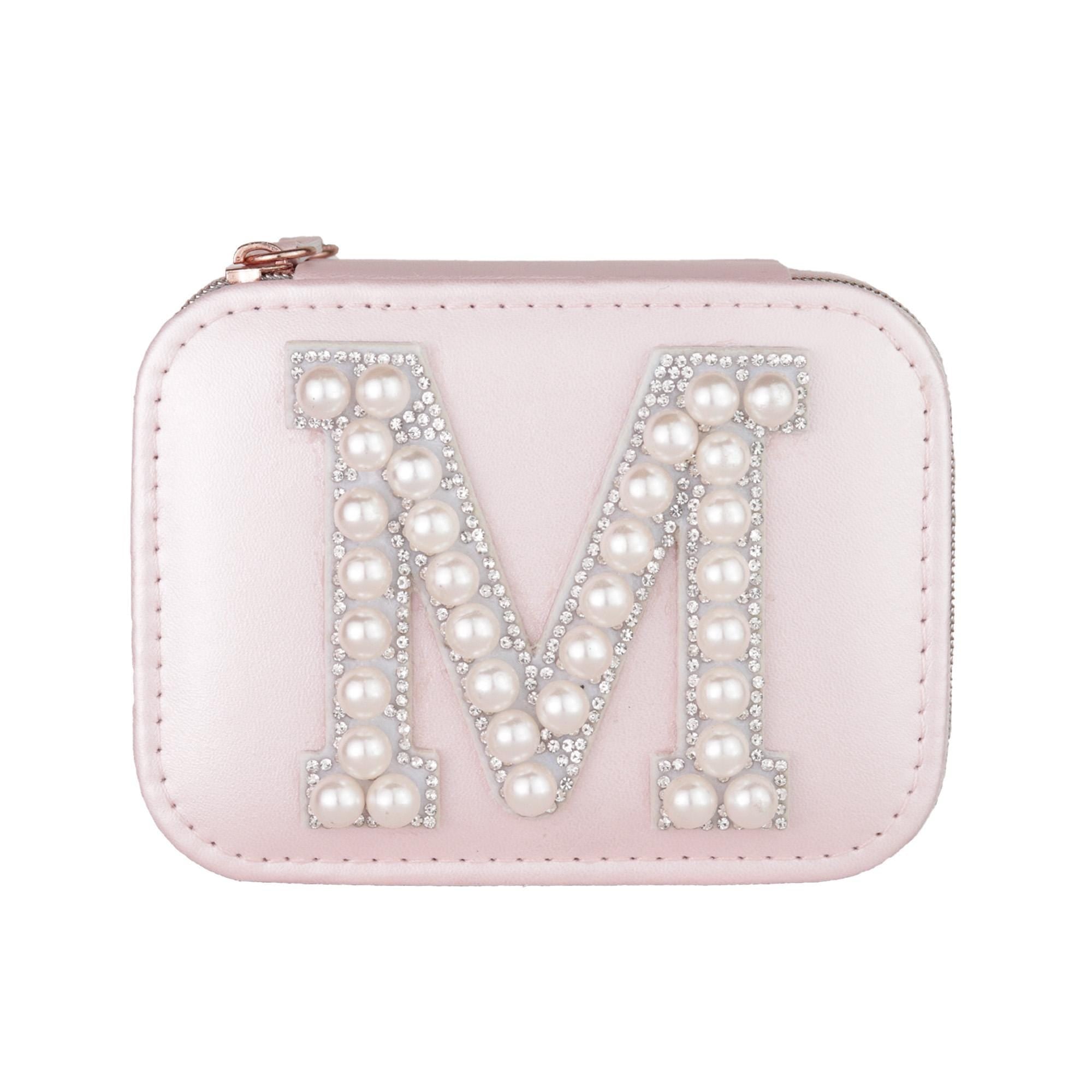 A pink leather pouch or case with a large letter &quot;M&quot; made of pearls and rhinestones on it.
