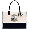 A tote bag with a black and white design, featuring a vintage-style text that reads 