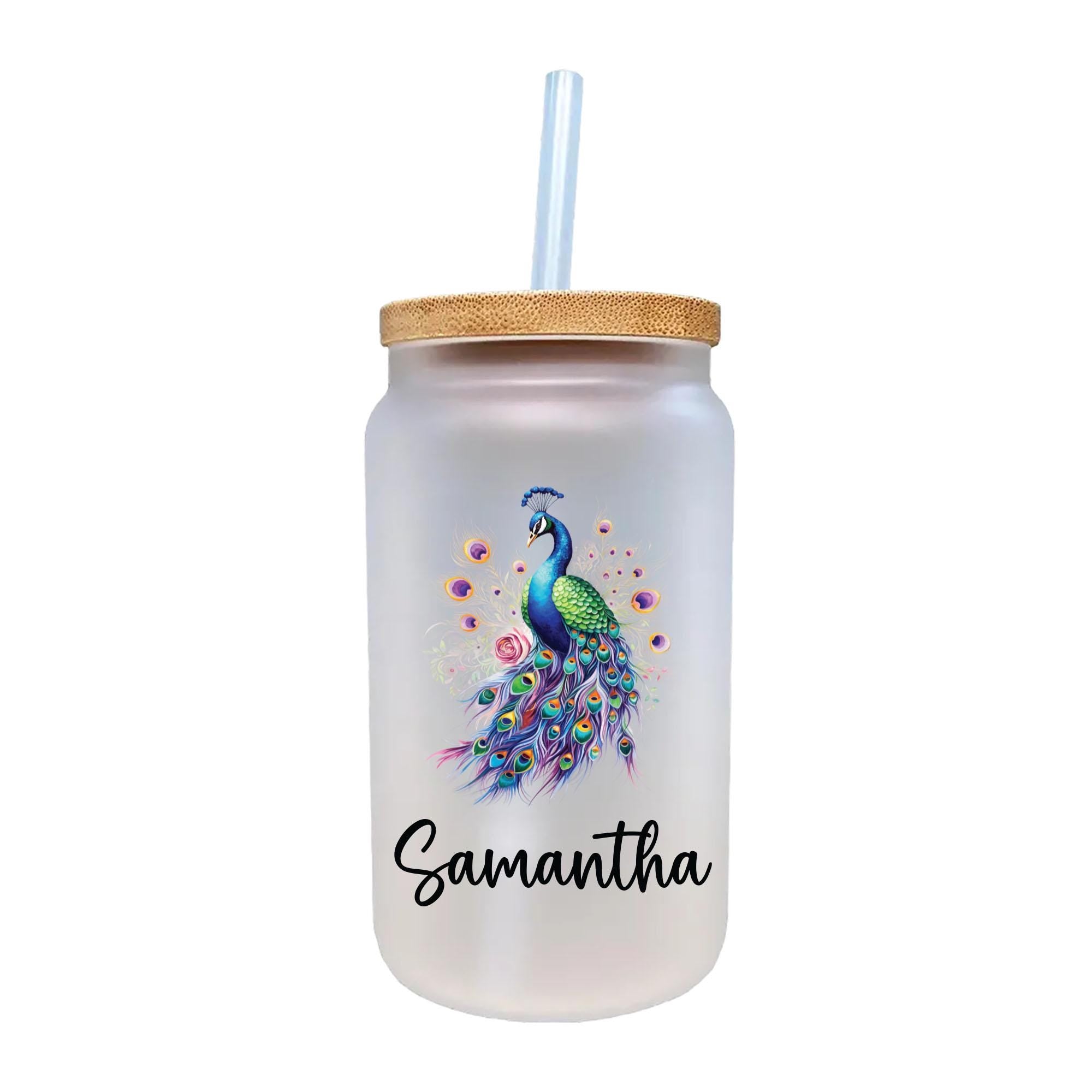 A frosted glass tumbler with a straw, featuring a colorful illustration of a peacock on the front.