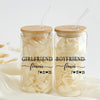 Two glass jars with straws, each containing a white substance, labeled with the text "GIRLFRIEND" and "BOYFRIEND" along with the numbers "7 21 25".