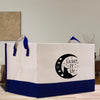 a white and blue shopping bag sitting on top of a wooden table