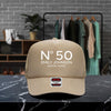 A beige baseball cap with the text "N° 50 EMILY JOHNSON AUSTIN, TEXAS" printed on it, placed on a marble countertop.