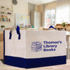 A large tote bag with the text "Thomas' Library Books" printed on it, featuring a stack of books and a blue and white design.