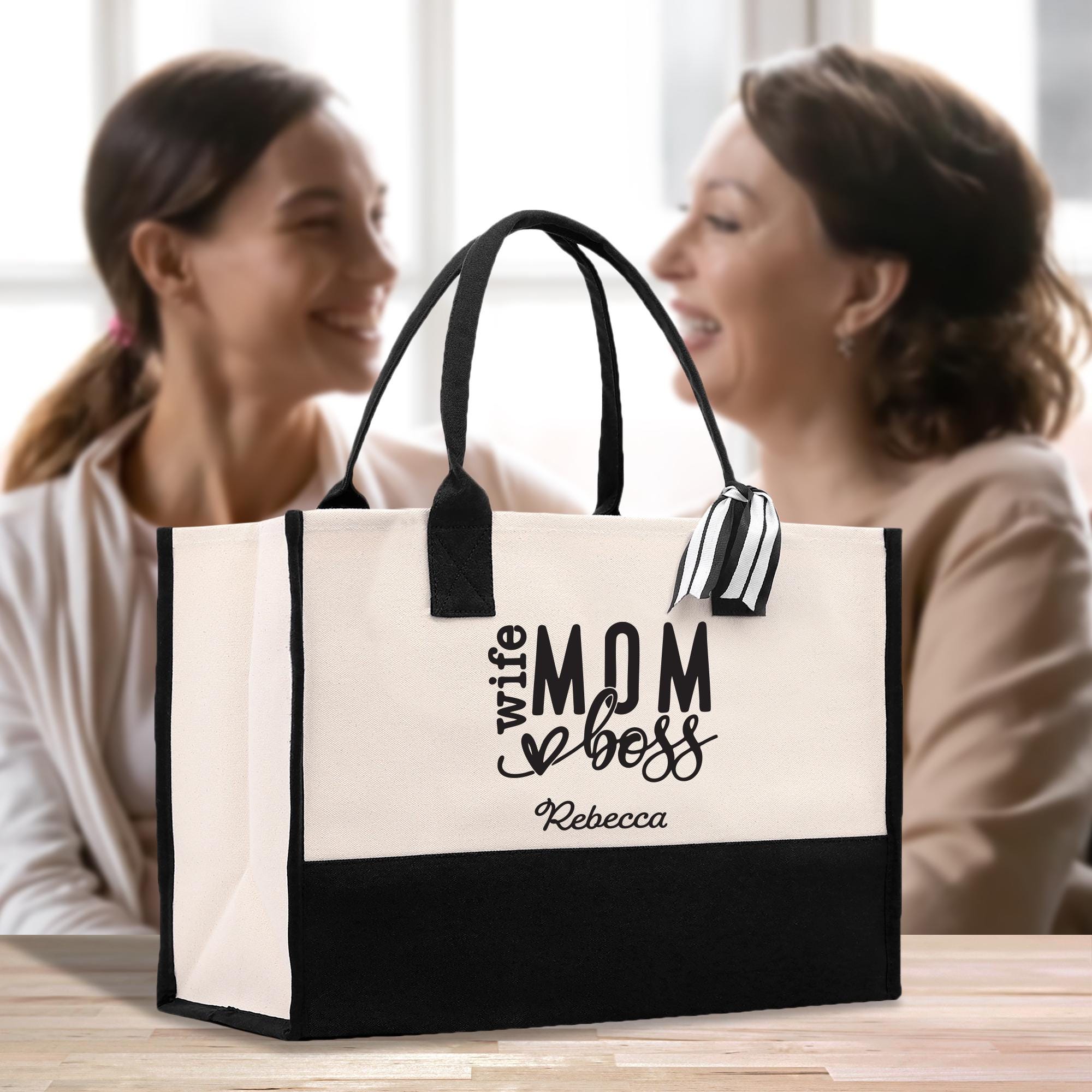 two women sitting at a table with a black and white bag